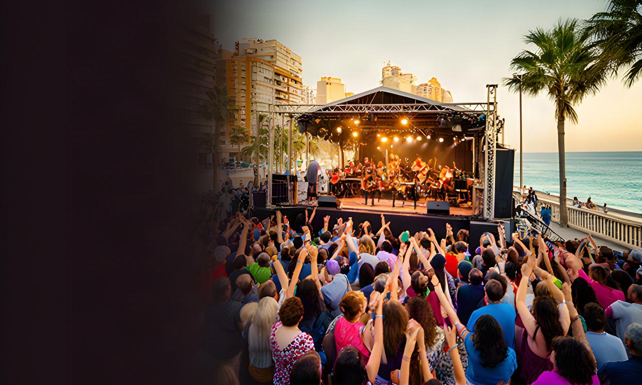 Público disfrutando de un concierto al aire libre junto al paseo marítimo de Benidorm