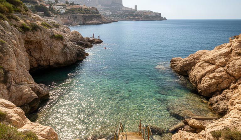Cala del Mal Pas de Benidorm entre rocas, agua transparente y pequeñas escaleras de acceso
