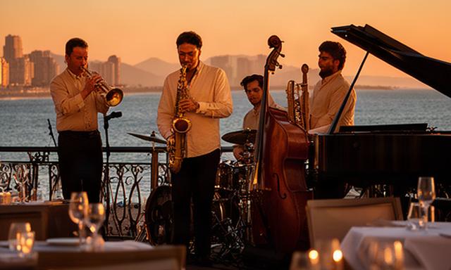 Músicos de jazz tocando al atardecer en una terraza frente al mar de Benidorm